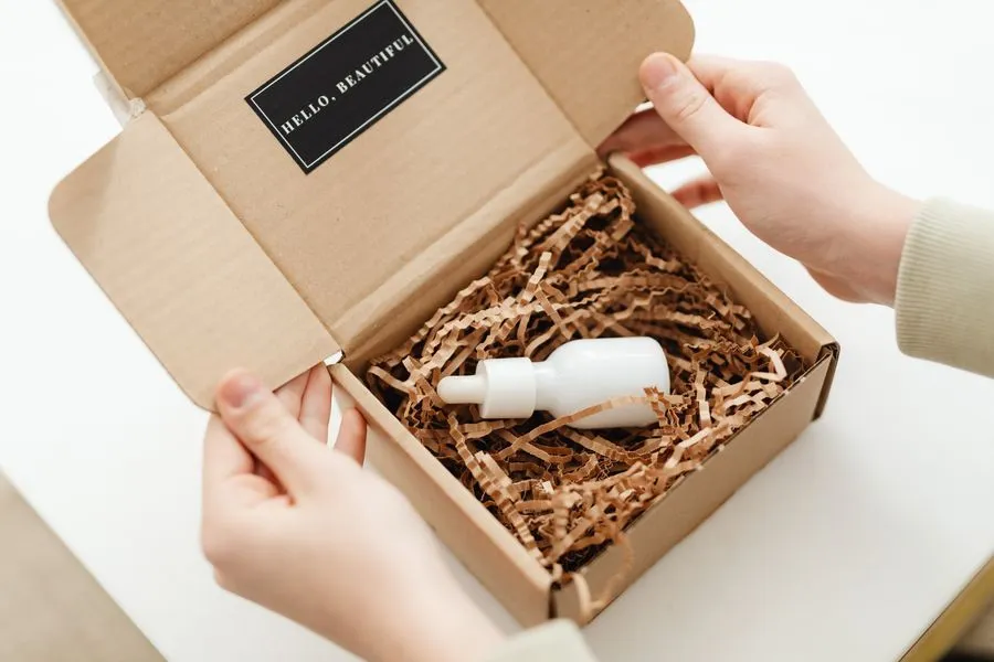 Hands opening a branded product package